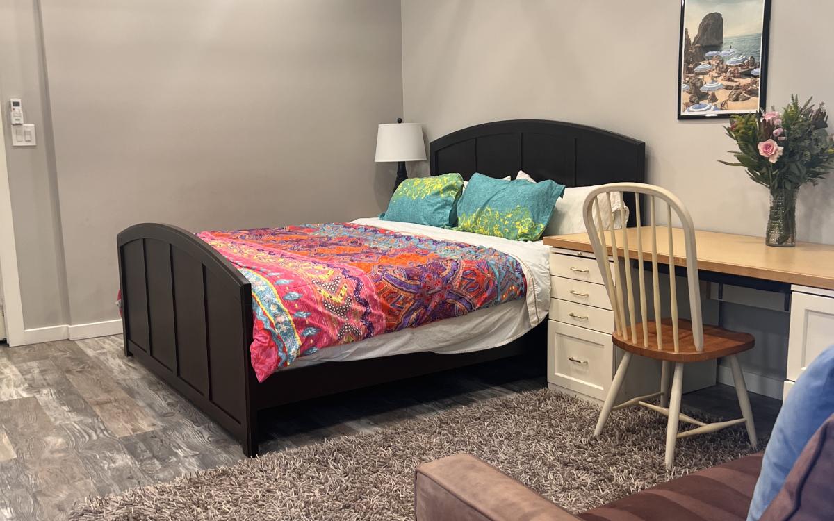 Interior photo with double bed, desk and partial couch.