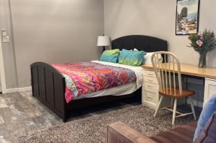 Interior photo with double bed, desk and partial couch.